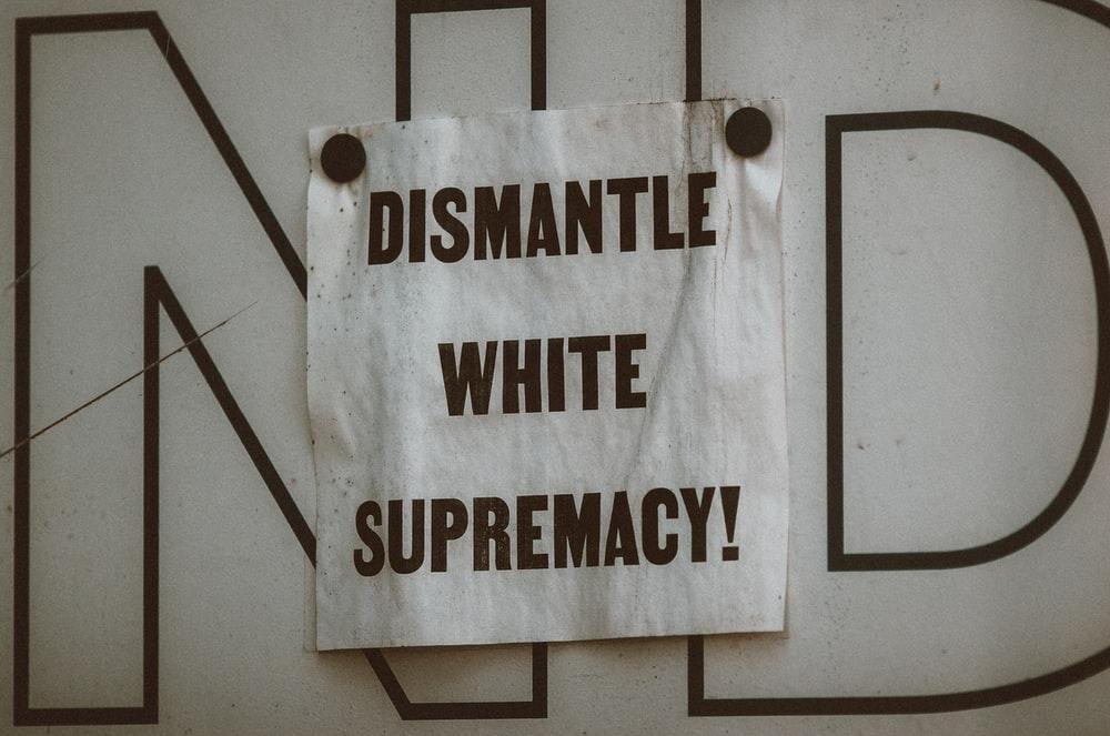A Flier Stuck on a Wall Reading, "Dismantle White Supremacy"